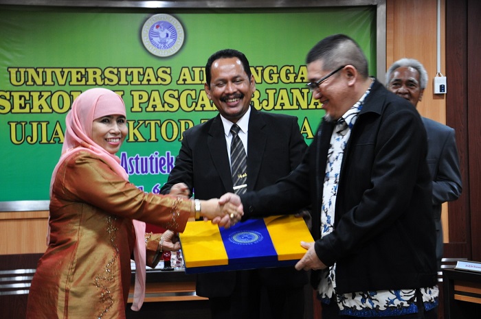 PROMOVENDUS Dr. Dwi Astutiek, S.Ag, M.Si., menerima piagam kelulusan Program Doktor di UNAIR. (Foto: Akhmad Janni)