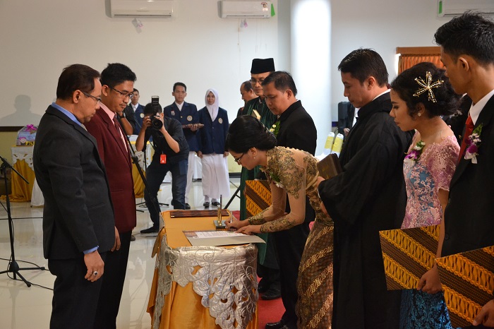 Salah satu NERS saat menandatangani surat pernyataan disaksikan dekan dan rohaniawan (Foto: UNAIR NEWS)