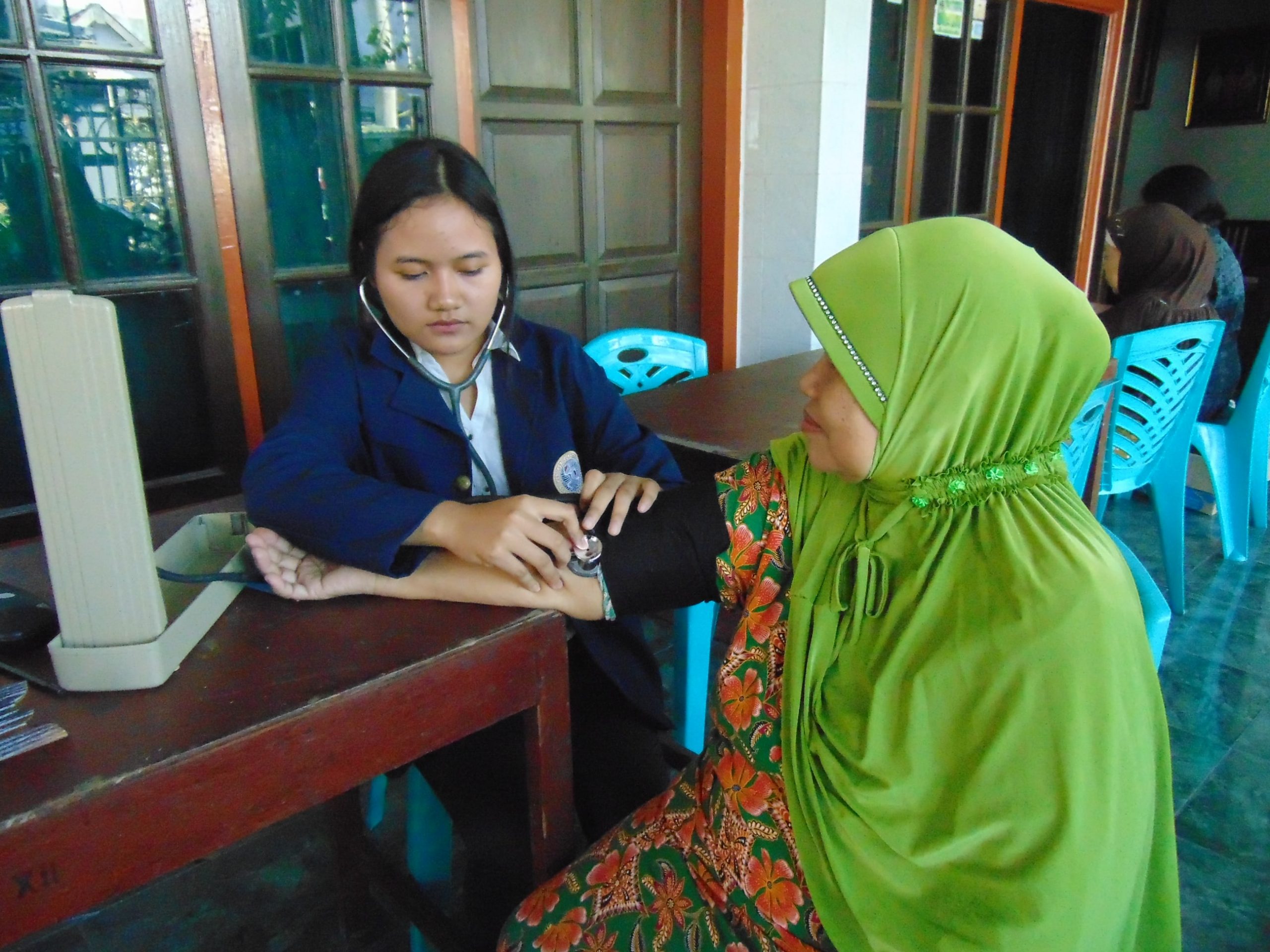 SALAH seorang warga diperiksa anggota tim KKN UMKM N Kecamatan Gubeng Surabaya Universitas Airlangga dalam kegiatan program kerja ”Sehat Bersama Masyarakat” pada Kamis (5/7). (Foto: Istimewa)