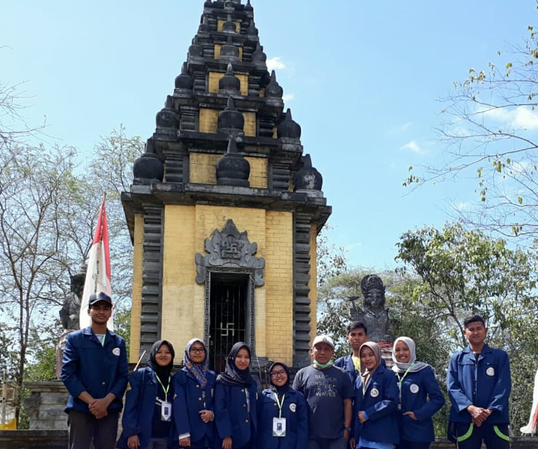 TIM KKN-BBM Universitas Airlangga berfoto bersama dengan parangkat Desa Kedungasri di depan Candi Purwo, Banyuwangi. (Foto: Istimewa)