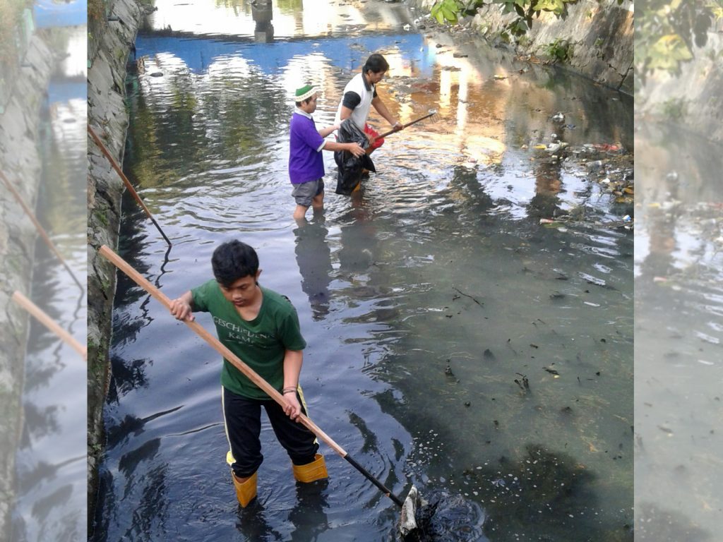 SEJUMLAH peserta aksi pembersihan kali di Karang Menjangan memunggut smpah dalam Kegiatan Sambermen. (Foto: Fariz Ilham)