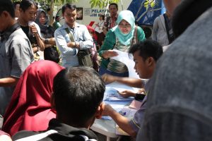 SEJUMLAH masyarakat tengah mengurus perpanjangan Surat Ijin Mengemudi (SIM) di tempat parkir Airlangga Convention Center (ACC), Kampus C, UNAIR, Rabu (5/9). (Foto: Agus Irwanto)