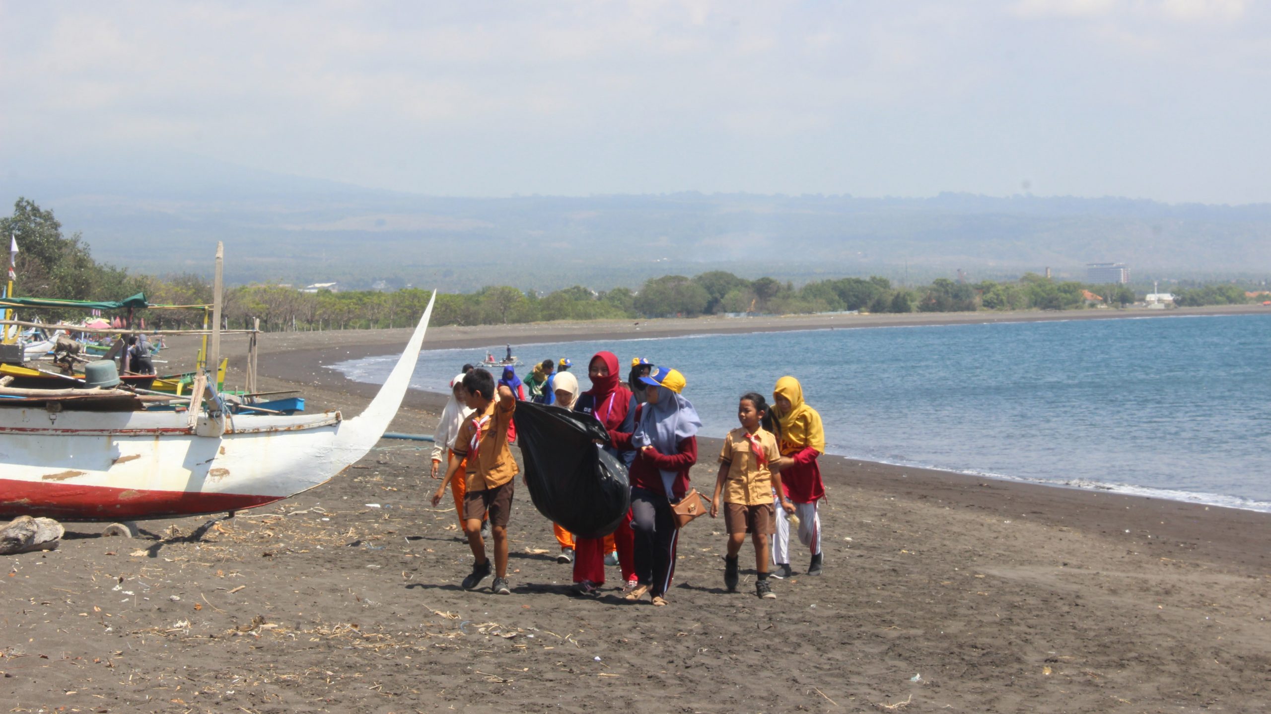 MAHASISWA FPK dan FKM bersama siswa-siswi SDN 2 Karangrejo membersihkan pesisir pantai Pulau Santen-Banyuwangi. (Foto: Bastian Ragas)