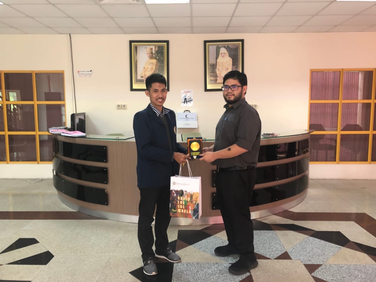 1. Penyerahan cinderamata oleh Wakil Presiden BEM UNAIR Fairuz Zuhair kepada Harris Ar-Rafi bin Mohd Zaini perwakilan Global Affairs Universitas Brunei Darussalam di Kantor ILIA. (Foto: Istimewa)