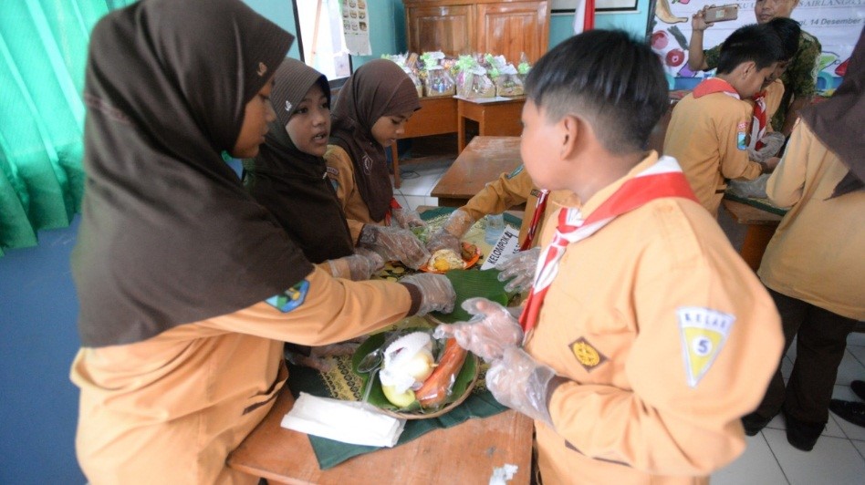 ANAK-anak MIN (Madrasah Ibtidaiyah Negeri) 1 Banyuwangi belajar membuat makanan atau sarapan yang bergizi dan sehat dalam kegiatan pengabdian masyarakat Fakultas Kesehatan Masyarakat (FKM) Program Studi di Luar Kampus (PSDKU) Universitas Airlangga di Banyuwangi pada Jum’at (14/12). (Foto: Agestin Awalin Kartikasari)