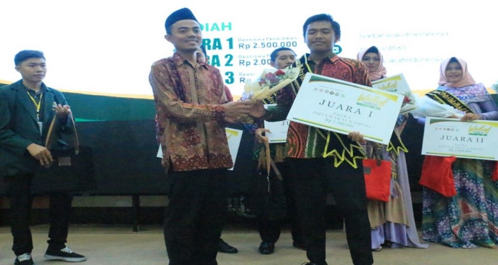SINTO, mahasiswa Fakultas Humum UNAIR, saat menerima serangkaian bunga sebagai ungkapan selamat dari salah seorang pengurus Badan Wakaf Indonesia (BWI) Jawa Timur dalam Pemilihan Duta Wakaf Kampus Jawa Timur 2018 di Gedung Theater UINSA pada 16 November 2018. (Foto: Istimewa)