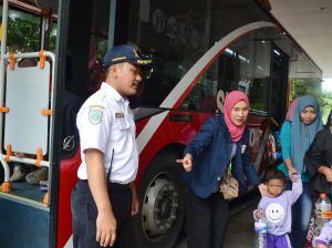 SALAH seorang mahasiswa UNAIR mengarahkan anak PAUD untuk naik Surabaya Bus. Sejumlah mahasiswa UNAIR mengelar kegiatan HAI TAYO: Program menabung sampah botol plastik bagi anak-anak PAUD PPT Kids Smile guna mengurangi sampah plastik dan membayar tiket Suroboyo Bus. (Foto: M. Najib Rahman)