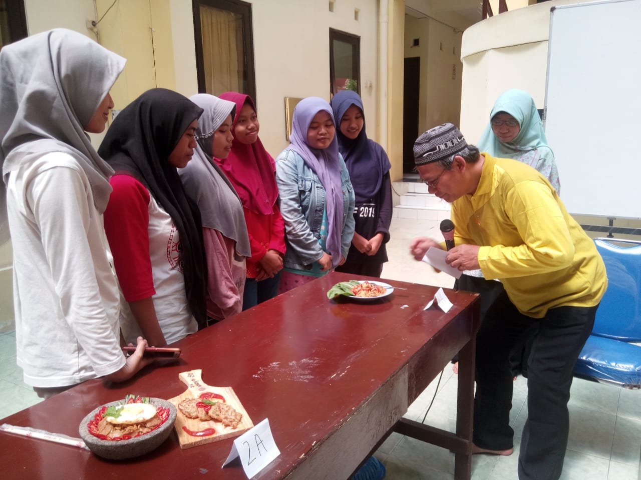 KETUA Asrama Mahasiswa UNAIR Drs. R. Arif Wibowo, M.si., saat menilai masakan hasil lomba memasak para penghuni Asrama Putri Universitas Airlangga pada Minggu (17/2/2019). (Foto: Istimewa)