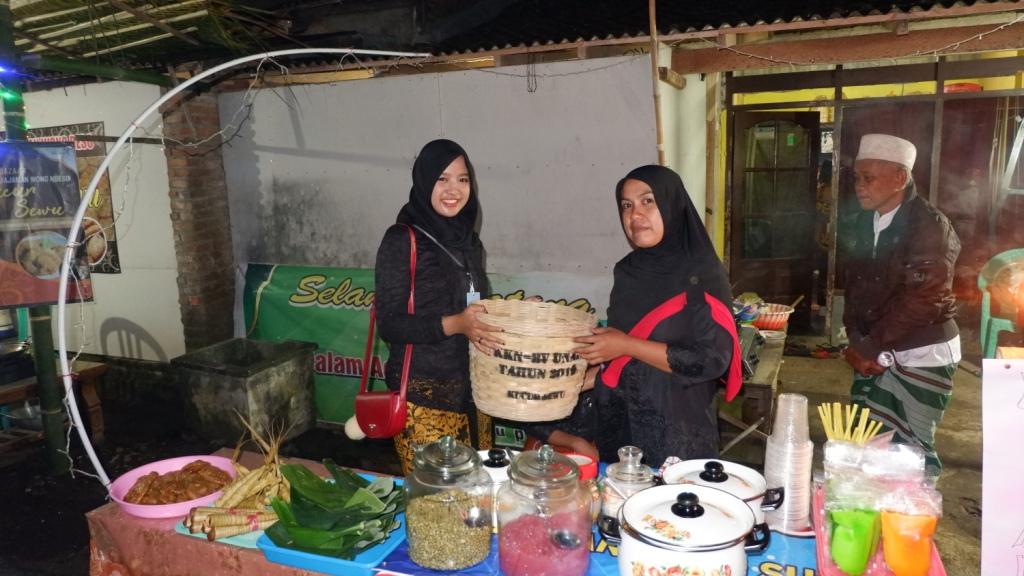 Salah satu mahasiswa KKN BBM UNAIR saat memberikan kenang-kenangan kepada warga setempat. (Foto: Istimewa)