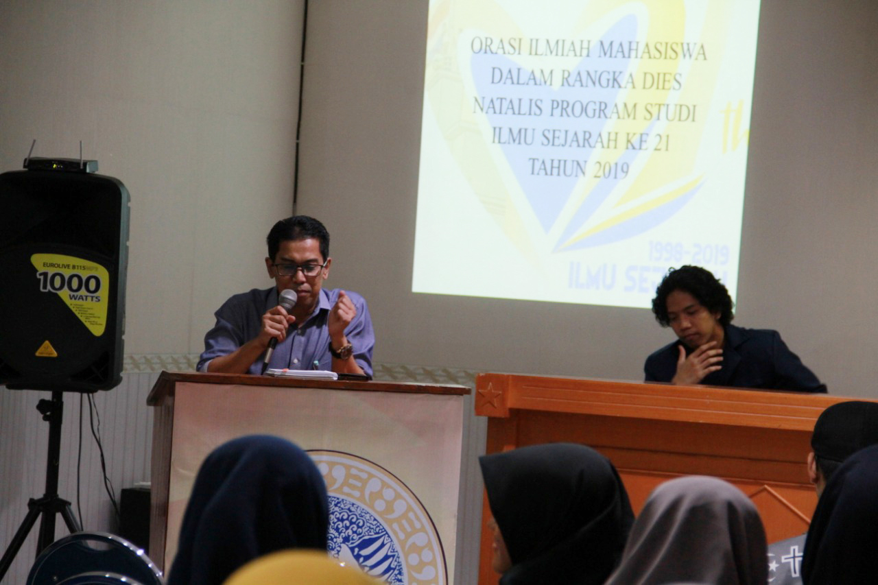 KEPALA Prodi Departemen Ilmu Sejarah Universitas Airlangga, Dr. Sarkawi B. Husain S.S., M.Hum., memberikan sambutan dalam orasi ilmiah pada peringatan dies natalis ke-21 di Chairil Anwar, Lantai 2 FIB UNAIR, pada Rabu (13/3/2019). (Foto: Rama)