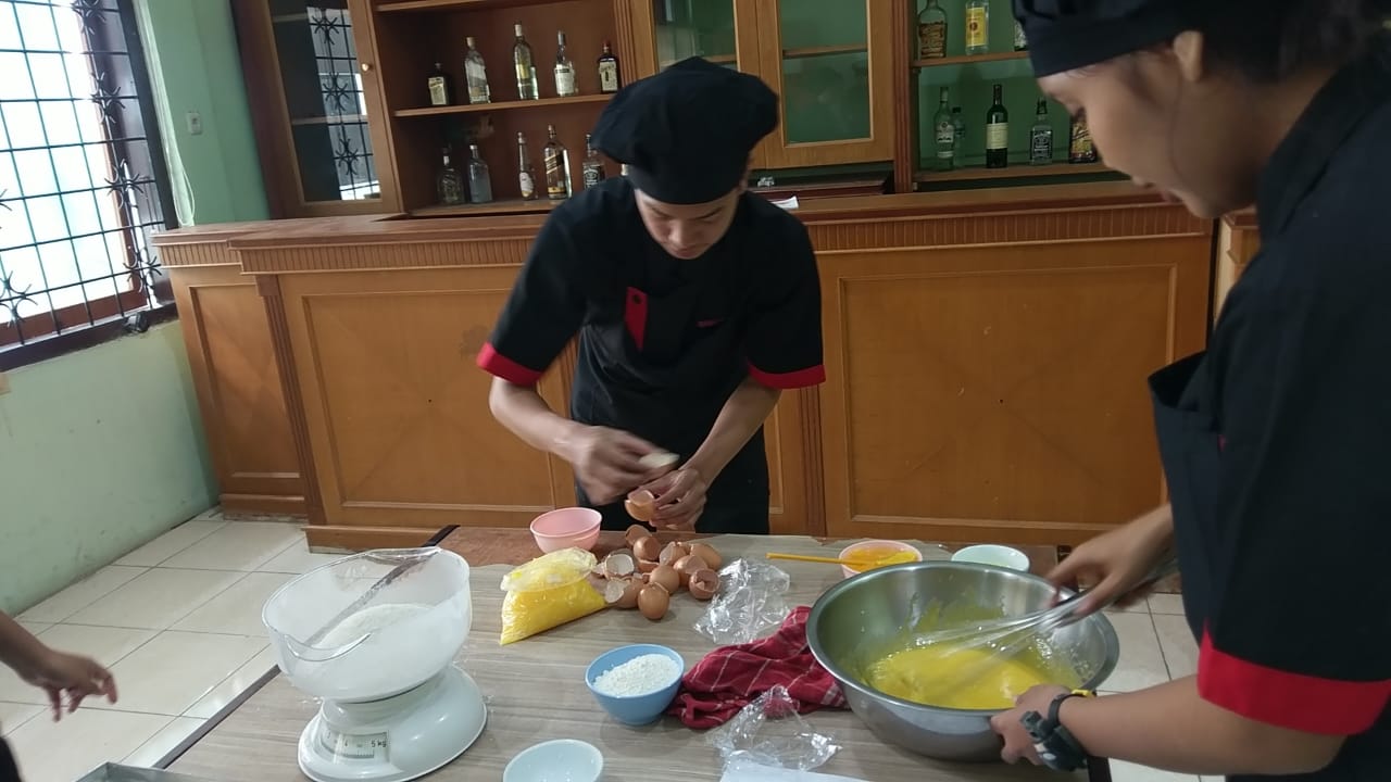 Pastry, Cake & Cream course students break eggs and mix the dough.