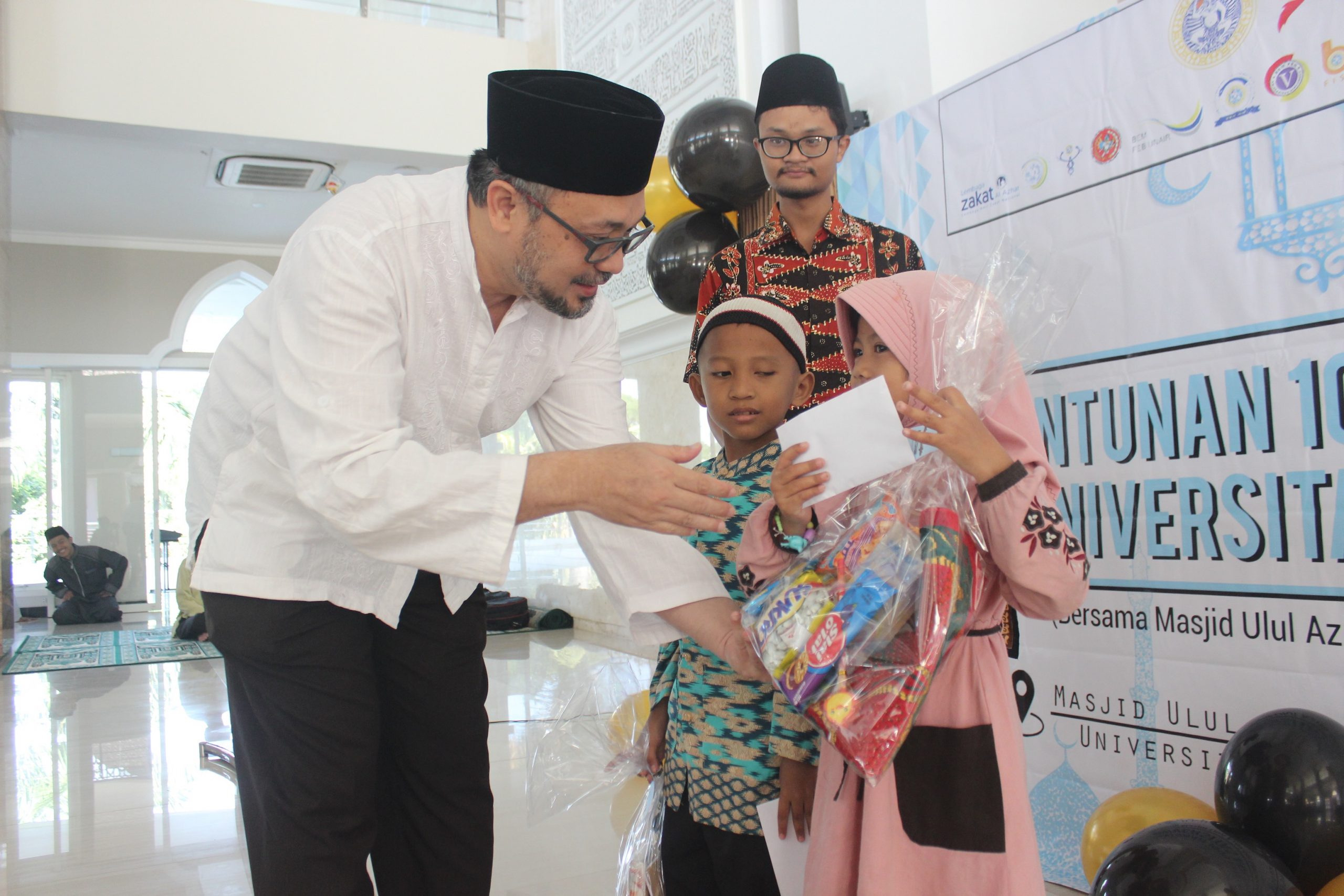 PROF., Ir. Moch. Amin Alamsjah, M.Si., Ph.D. wakil rektor III UNAIR ketika memberikan santunan dan bingkisan secara simbolis kepada perwakilan anak yatim pada acara Satunan 1000 Anak Yatim Universitas Airlangga. (Foto: Istimewa)