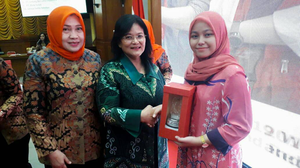 Devi Anggraini (right) member of 25th KSR PMI receives the award from Indonesian Red Cross, Blood Donation Unit in Surabaya.