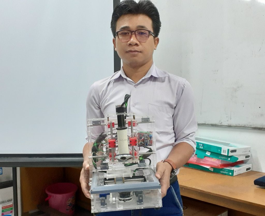 2. Alat mikroskop portable dipegang Winarno, S.Si, M.T., tim dosen dari UNAIR pada Selasa (18/6/19). (Foto: Istimewa)