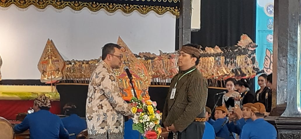 WAKIL Rektor III UNAIR menyerahkan gunungan kepada peserta pertama dalam Lomba Dalang Muda Wayang Majapahit Universitas Airlangga 2019 di Taman Budaya Jawa Timur Surabaya, Sabtu (20/72019). (Foto: Asthesia Dhea)
