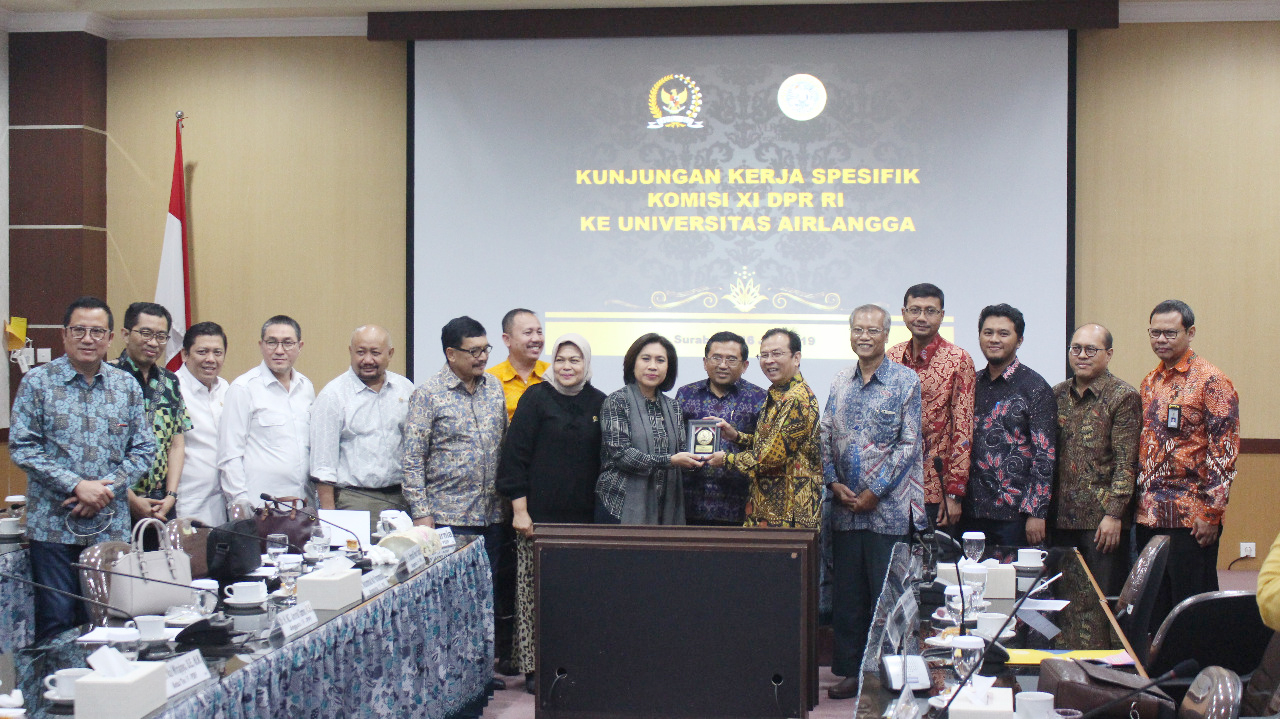 (ENAM Dari KIRI) Wakil Rektor II UNAIR Dr. Muhammad Madyan, SE., M.Si., M.Fin., menerima cenderamata dari anggota DPR RI Indah Kurnia disaksikan Ketua Tim Komisi XI DPR RI I Gusti Agung Rai Wirajaya, SE., MM., beserta rombongan dari Komisi XI DPR RI. (Foto: Alifauzan)