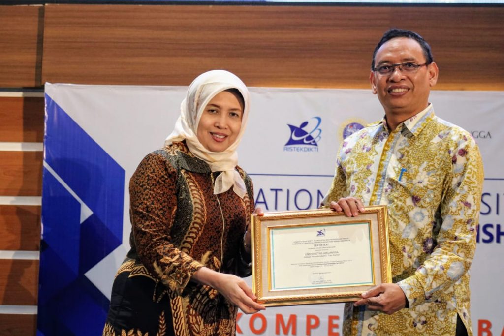 Prof. Dr. Rina Indiastuti, S.E., M.SIE. selaku Sekretaris Dirjen Belmawa Kemenristekdikti, secara langsung menyerahkan piagam penghargaan kepada Prof. Dr. Mohammad Nasih, SE., M.T., Ak., CMA selaku Rektor UNAIR atas suksesnya penyelenggaraan NUDC dan KDMI 2019 di Aula Garuda Mukti pada 18 Juli 2019 . (Foto: Agus Irwanto)