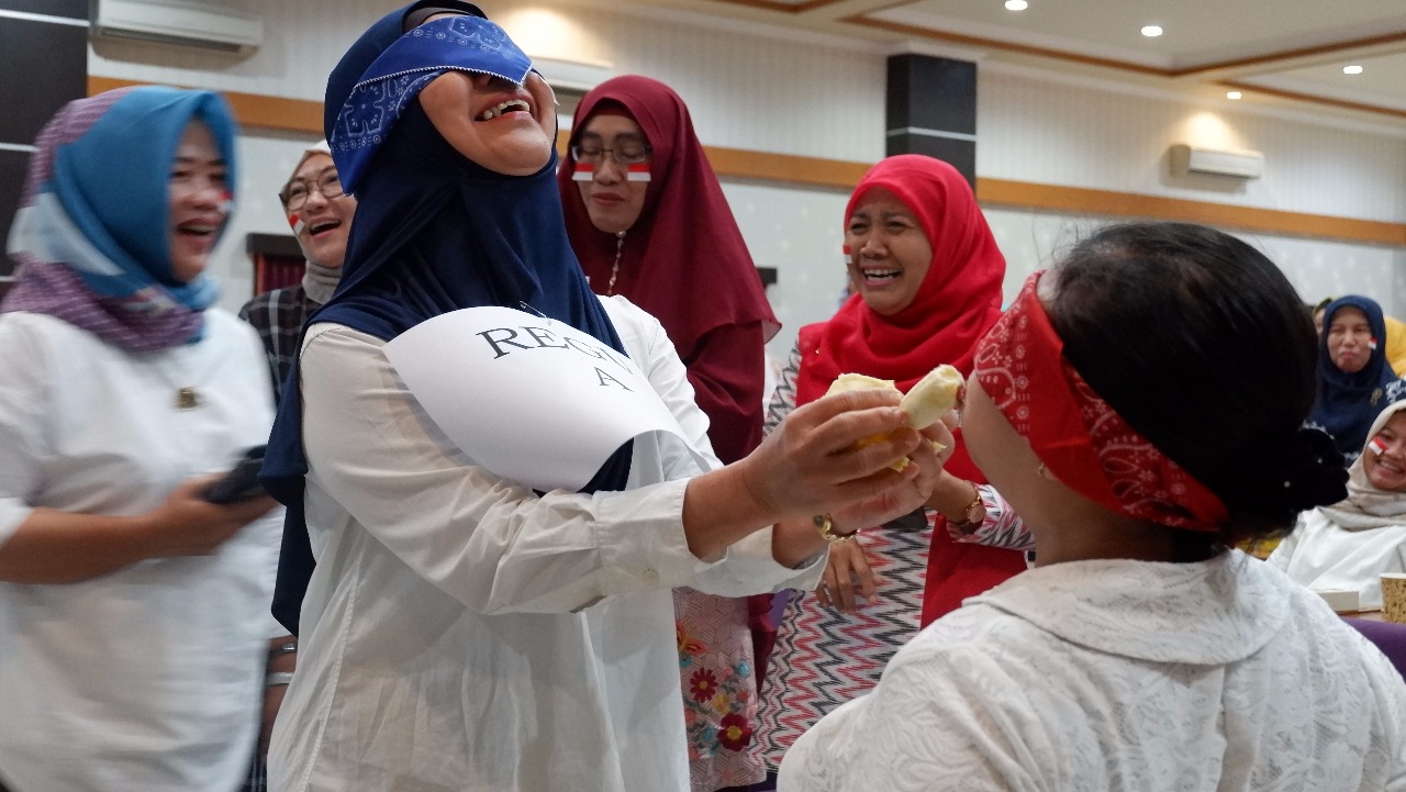 PESERTA yang terdiri dari ibu-ibu Dharma Wanita Persatuan (DWP) Universitas Airlangga tampak heboh ketika lomba suap pisang, di Aula Kahuripan, Kantor Manejemen UNAIR (16/8/2019). (Foto: Fariz Ilham Rosyidi)