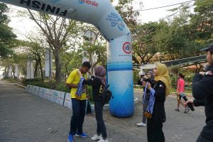 PESERTA yang sudah sampai di garis finish akan diberikan medali oleh panitia pada Minggu (22/9/2019) di sekitar ACC Kampus C UNAIR. (Foto: Istimewa)