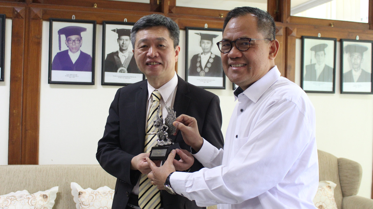 Tamkang University Taiwan representative, Sin Cheng Lin, Ph.D received a souvenir from UNAIR Vice Rector I, Prof. Dr. Djoko Santoso, dr., Ph.D., Sp.PD.K-GH.FINASIM after the meeting of strengthening the collaboration between these two universities in Vice Rector Room 1, Floor 4, UNAIR Management Office on Friday, November 1. (Photo: Muhammad Alif Fauzan)