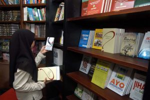 SEORANG perempuan mencari buku di perpusatakaan. (Foto: Istimewa)