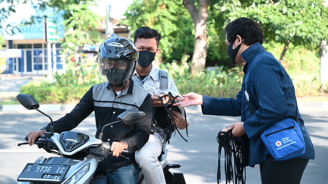 SALAH seorang mahasiswa memberikan masker kepada peserta UTBK di Pintu Masuk Kampus C UNAIR, dekat ACC, pada Rabu (22/7/2020). (Foto: M. Alif Fauzan)