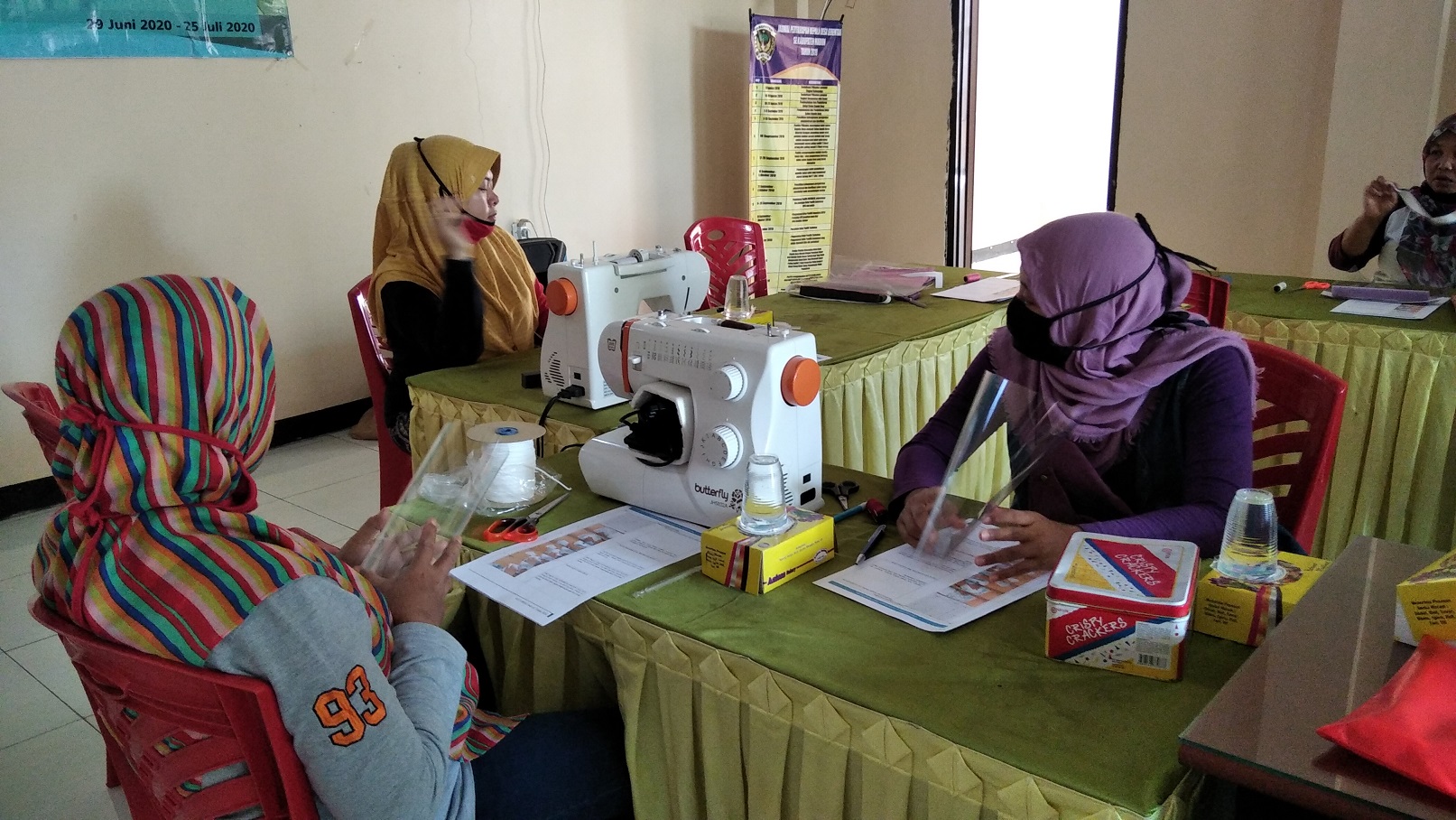 IBU-ibu anggota PKK tengah berlatih membuat masker dan face shield bersama Tim KKN UNAIR Kertosari Madiun (dokumentasi pribadi).