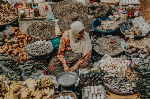 Ilustrasi UMKM: Seorang pedagang menjajakan dagangannya di pasar. (Foto: litbang.kemndagri.go.id))