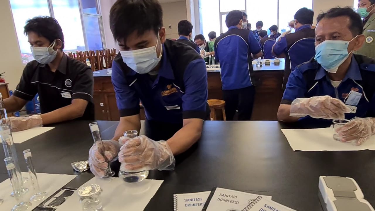 SITUASI Petugas Kebersihan ketika melakukan praktek hand sanitizer di Fakultas Farmasi UNAIR. Foto : Tim Pengmas. (Foto: Tim Pengmas)
