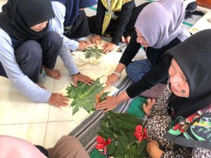 Mahasiswa BBK mengajari masyarakat cara membuat motif di atas totebag dengan menggunakan teknik ecoprint. (Sumber : Dokumentasi Pribadi)