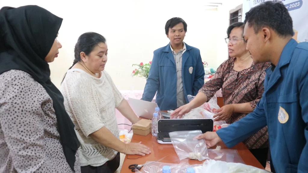 Tim Pengmas FPK UNAIR saat mengenalkan strategi pengemasan produk pada UMKM lewat pengabdian masyarakat (Foto: Istimewa)