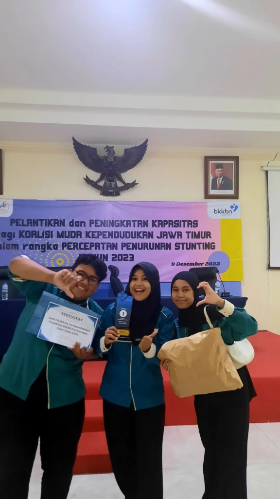 Tiga mahasiswa Ilmu Komunikasi UNAIR berfoto Bersama usai meraih sebagai juara 1 dalam Lomba Bedah Isu-isu Kependudukan 2023. (Foto : Istimewa)