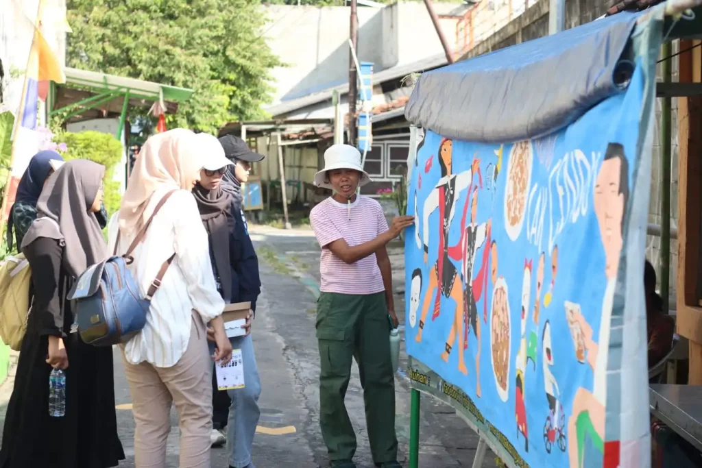 Spot lukisan karya Redi Murti dalam Kuratorial Tour Kampung Plampitan, bersama mahasiswa dan Anitha Silvia