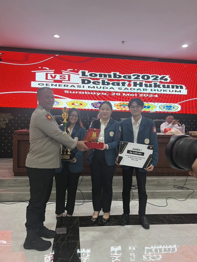 Penyerahan piala oleh penyelenggara kepada delegasi FH UNAIR. (Foto: Istimewa)