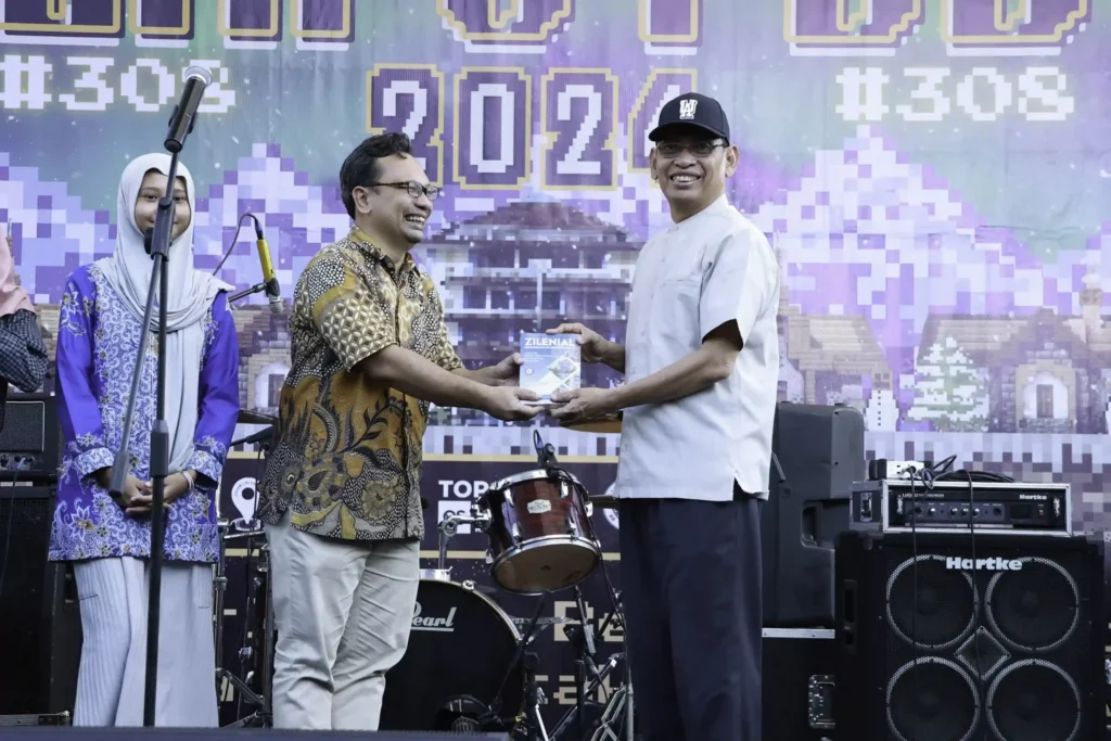 UPKK Chairman Syahrur Marta Dwisusilo PhD presents a book written by PDB students to UNAIR Rector Prof. Dr. Mohammad Nasih. (Photo: PKIP UNAIR)
