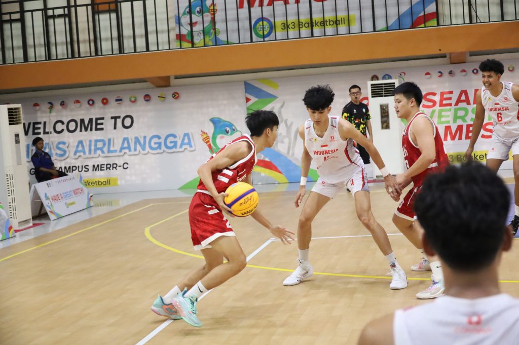 Pemain Laos berusaha melewati pemain Indonesia