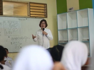 Associate Professor Dr. Aida Syarinaz Binti Ahmad Adlan delivers a presentation on smoking addiction during a community outreach event with the Department of Psychiatry, FK UNAIR (Photo: By courtesy)