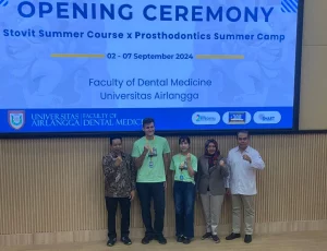 UNAIR Dean of Dental Medicine, Prof. Dr. Muhammad Luthfi, drg, MKes, Sp Perio(K), presents symbolic ID cards to representatives of the Stovit Summer Camp X Prosthodontics Summer Camp 2024 participants (Photo: Personal Documentation)