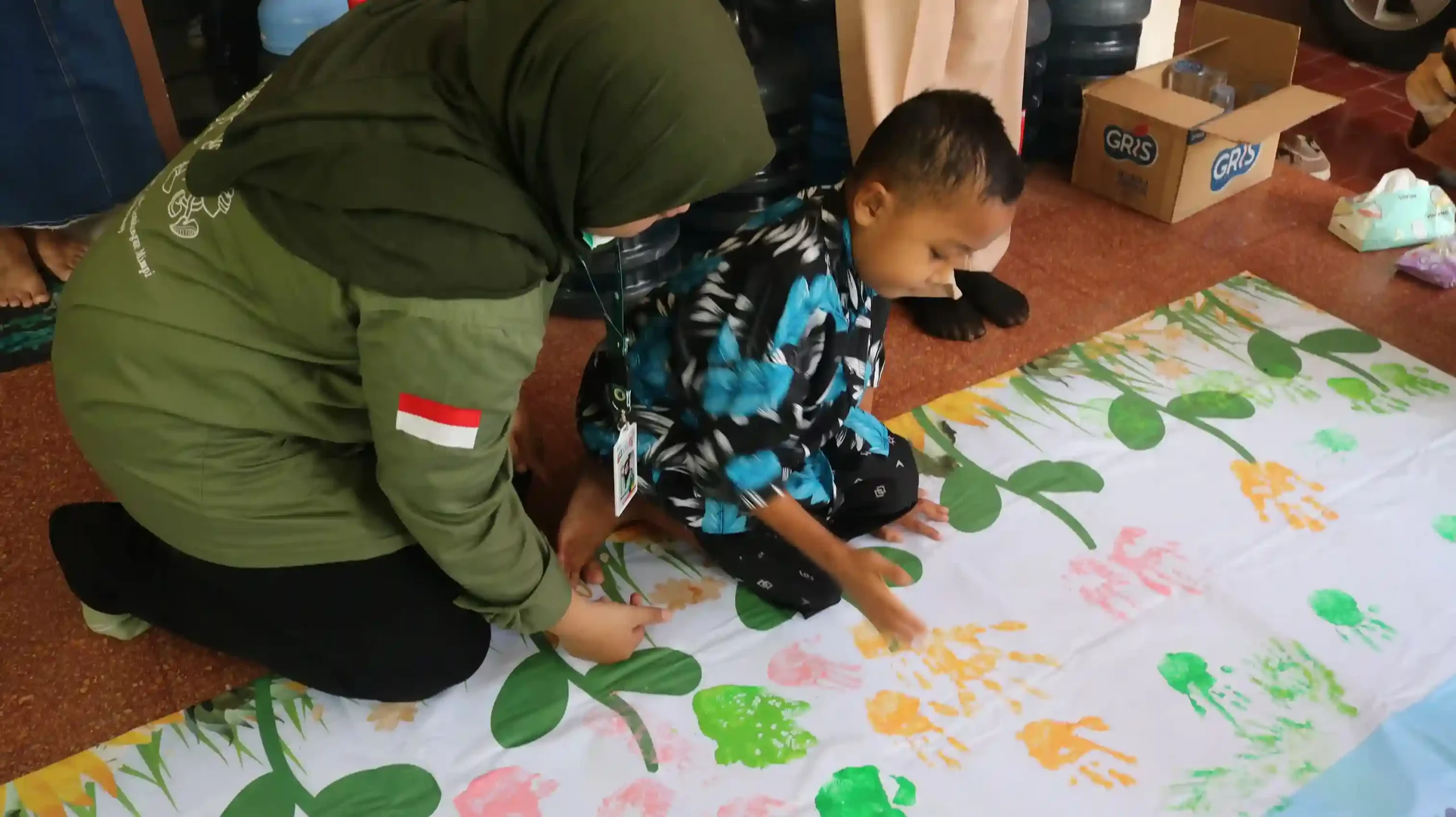 Ali, salah satu anak pejuang kanker di YPKAI ikut serta melakukan cap tangan di atas banner (Foto: Istimewa)