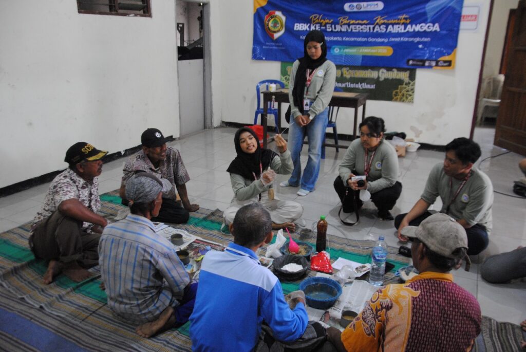 The community service program team collaborate with Karangkuten residents to create mineral blocks