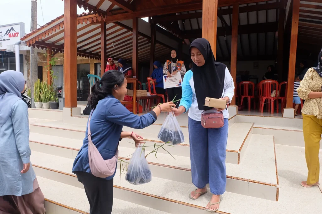 Mahasiswa Kesmas FIKKIA tengah membagikan tanaman TOGA pada masyarakat Desa Licin
