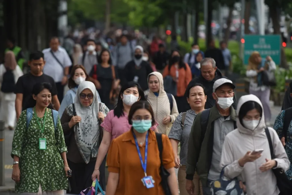A crowd of workers making their way through a busy area