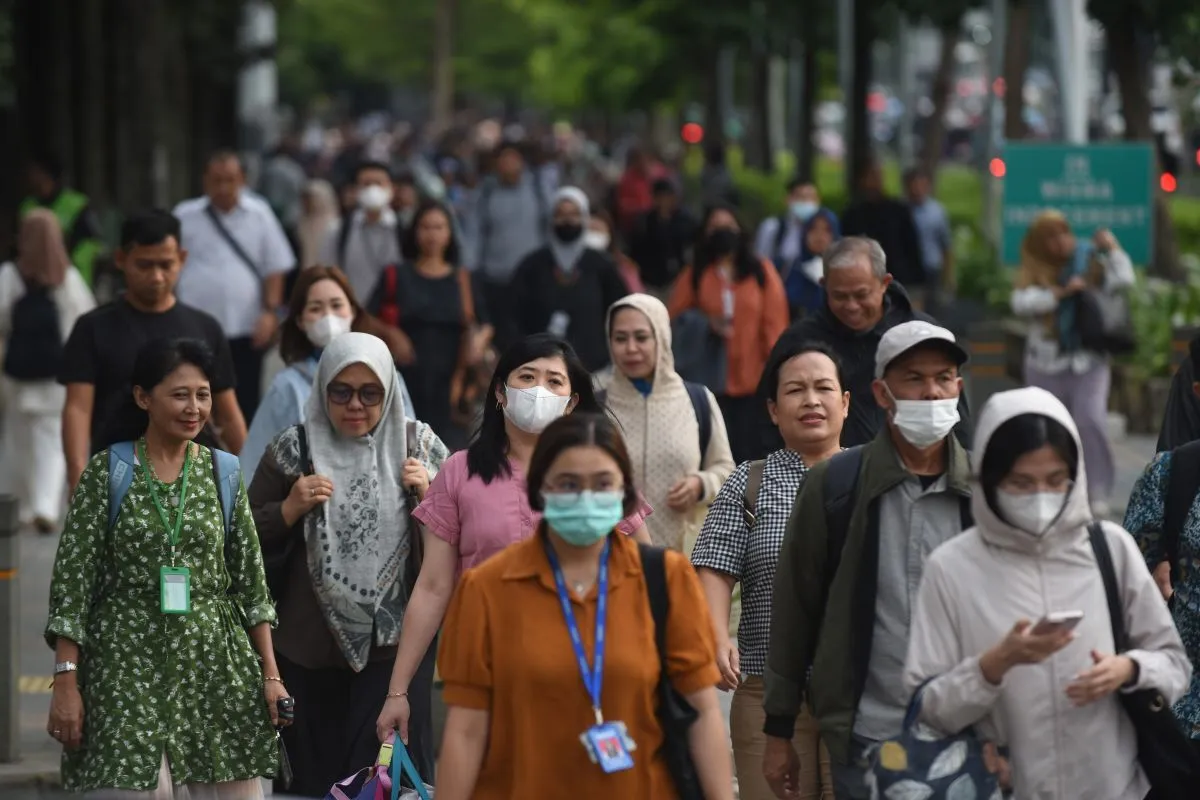 A crowd of workers making their way through a busy area