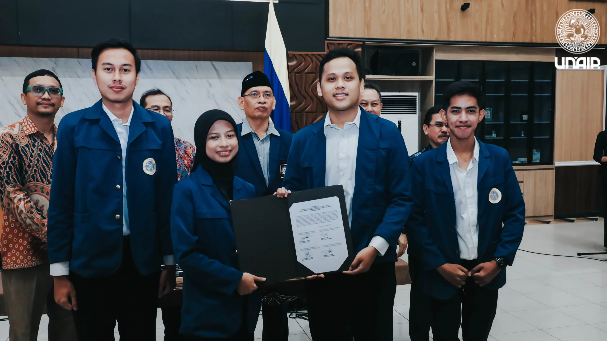 Head of UNAIR BEM 2025, Ziva-Melvin, receives the inauguration document from a university representative at the UNAIR Management Office Hall (Photo: PKIP)
