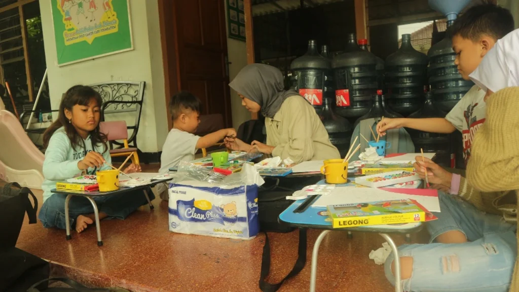 Muhimatul Khoiriyah, pendiri komunitas Colourise, saat mendampingi anak-anak penderita kanker YPKAI Surabaya melukis sebagai media terapi seni edukasi dan hiburan. (Foto: Istimewa).
