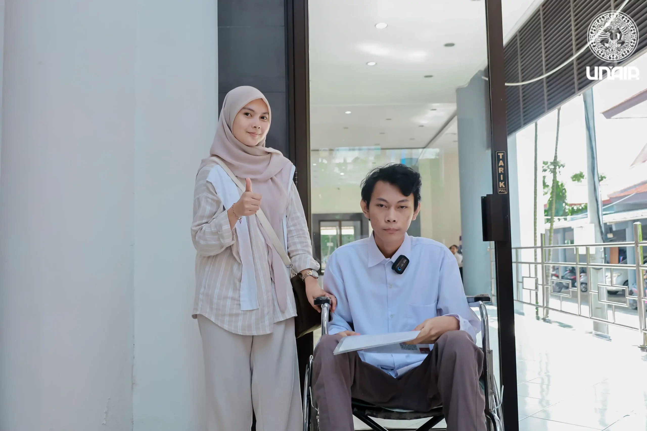 Ibrahim Thoriq Addyan, salah satu peserta UTBK penyandang disabilitas asal Sidoarjo bersama pendamping (Foto: PKIP UNAIR)