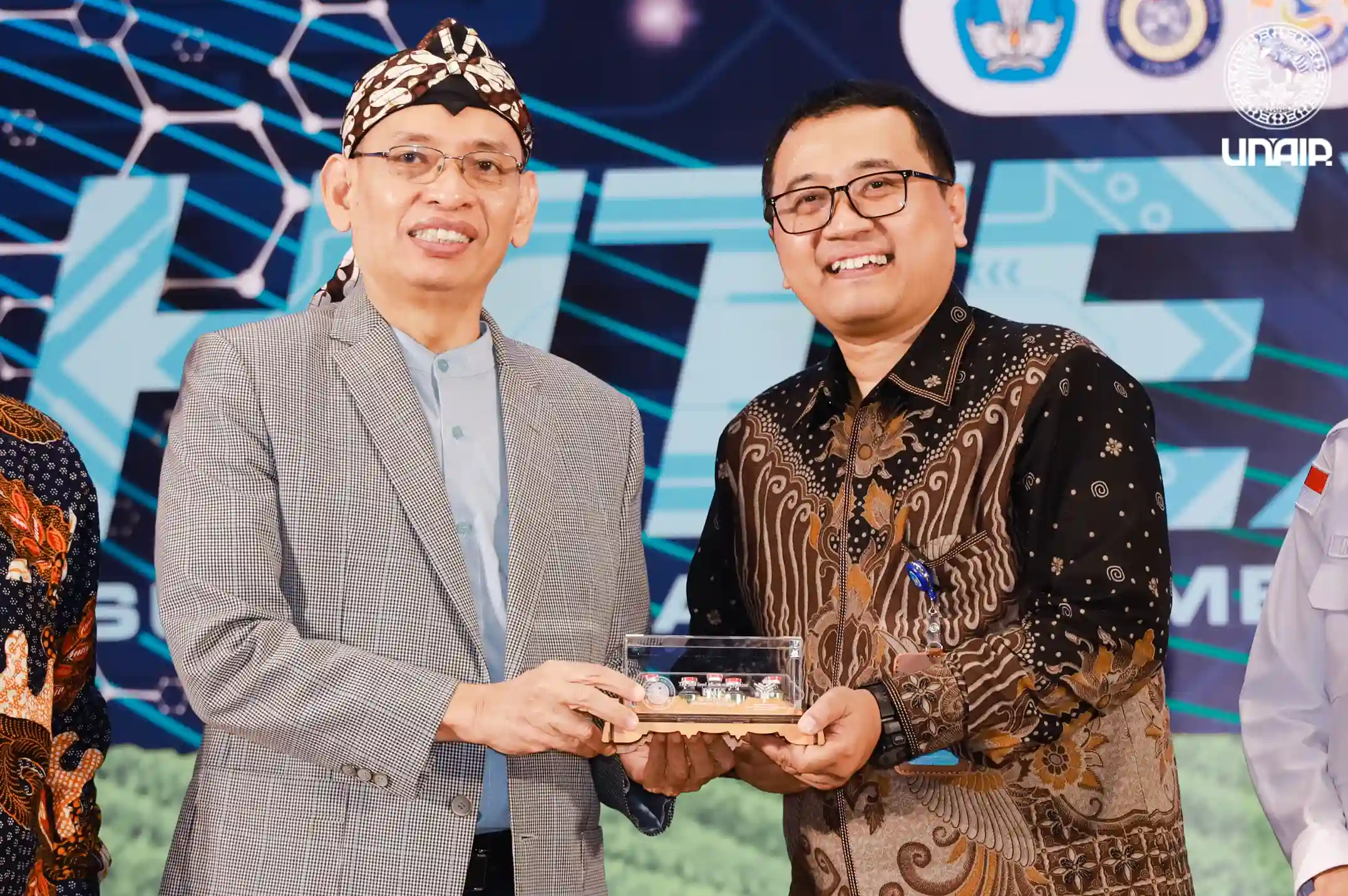 UNAIR Rector Prof. Dr. Mohammad Nasih, M.T., Ak., C.A., symbolically presents vaccine seed to institutional partners, including Prof. Yos Sunitiyoso, S.T., M.Eng., Ph.D., Director of Downstreaming and Partnerships at the Directorate General of Research and Development, Ministry of Higher Education, Science and Technology. (Photo: PKIP UNAIR)