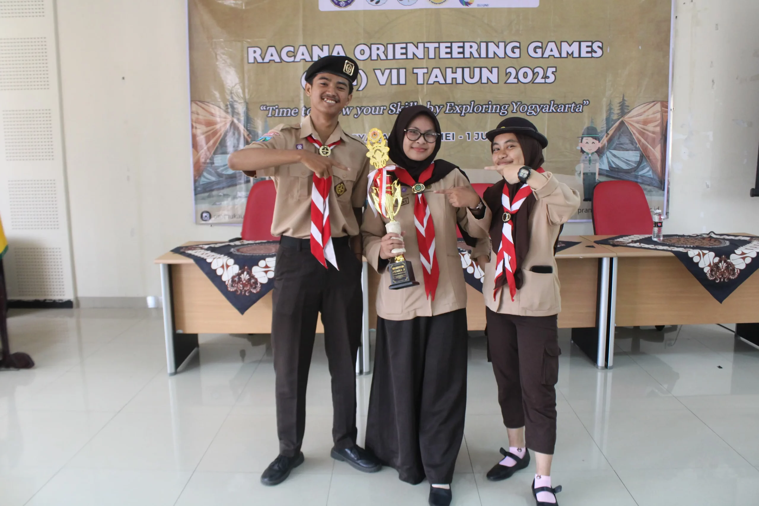 Nadiah Tulloh Endrayanti (tengah), Ersa Bayu Aditiya (kiri), dan Syellovea Anggun Cahyani (kanan) berfoto usai menerima trofi Juara 3 kategori Newsletter dalam ajang Racana Orienteering Games (ROG) VII 2025 di Yogyakarta (Foto: Dokumentasi Tim)