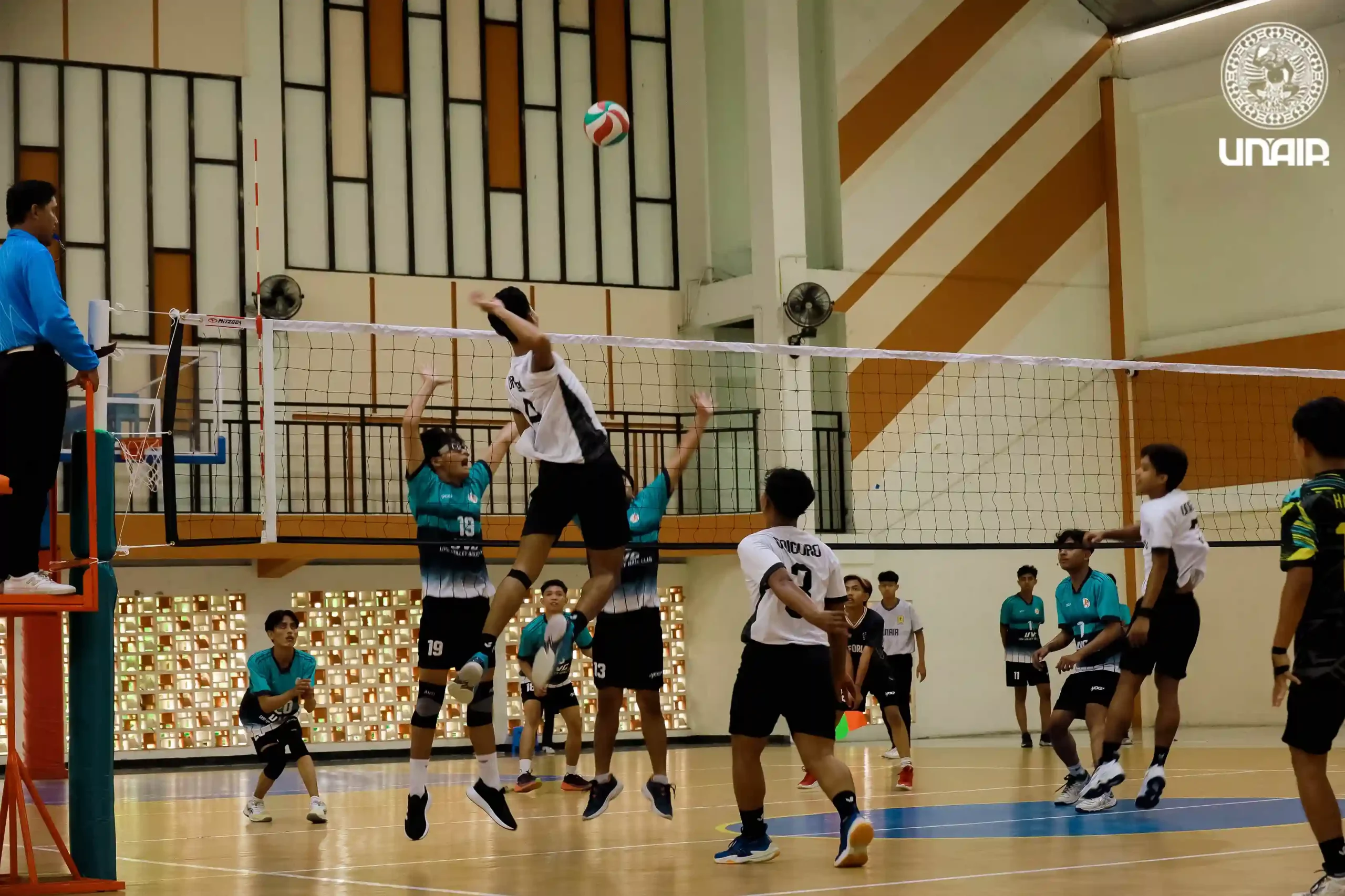 Pemain tim voli putra melakukan smash ke arah tim lawan dalam laga POMPROV III Jatim yang digelar di GOR Kampus MERR-C UNAIR, Minggu (1/6/2025) (Foto: PKIP UNAIR)