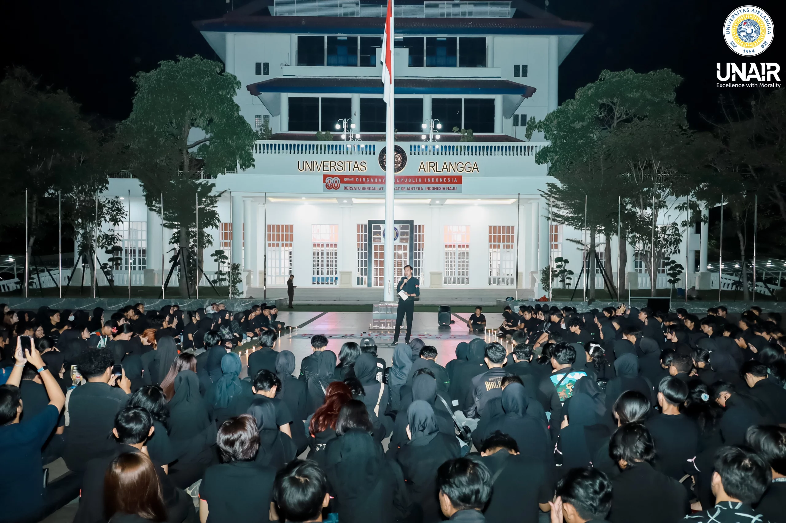 Wakil Ketua BEM Universitas Airlangga Melvin Hermawan saat menyampaikan refleksi di depan ratusan mahasiswa UNAIR dalam aksi simbolik Kidung Duka Airlangga, di depan Gedung Manajemen Rektorat Kampus MERR-C, pada Sabtu (06/9/2025). (Dokumentasi: PKIP UNAIR)